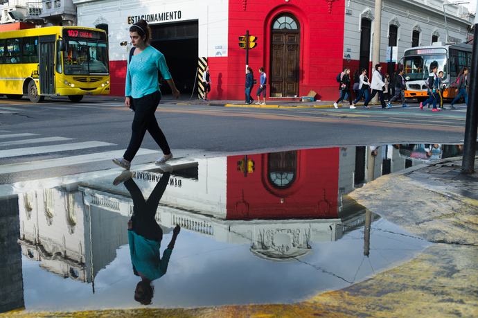 A girl walk by a puddle after a storm in Rosario
